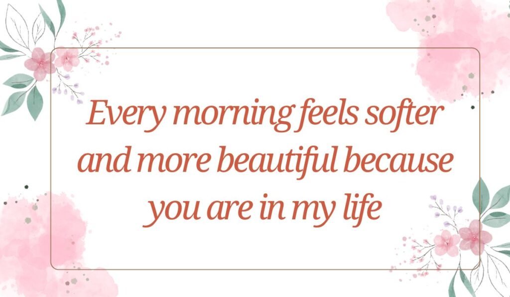White rectangular card decorated with soft pink watercolor accents and delicate floral corner illustrations, featuring sweet good morning messages for her: "Every morning feels softer and more beautiful because you are in my life".
