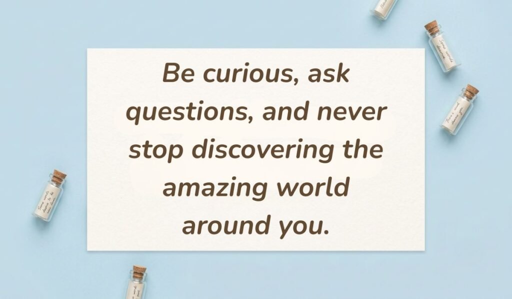 alt="Soft blue flat lay with tiny glass message bottles displaying a curiosity quote of the day for kids reading, 'Be curious, ask questions, and never stop discovering the amazing world around you.'"