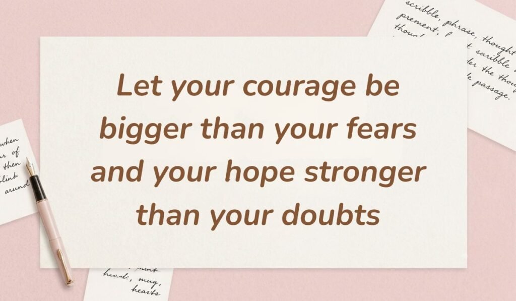 Soft pink desktop flat lay with handwritten script scraps and a fountain pen showcasing quotes for bravery and courage reading, "Let your courage be bigger than your fears and your hope stronger than your doubts."