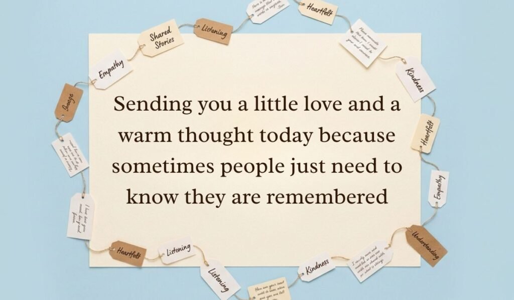 Soft blue surface decorated with a ring of string-bound message tags showcasing thinking of you messages reading, "Sending you a little love and a warm thought today because sometimes people just need to know they are remembered"